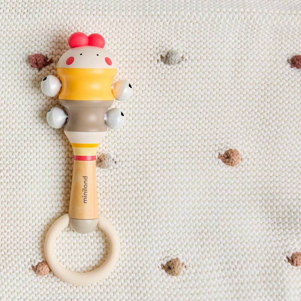 Miniland - Chick bell – sonaglio adagiato su una coperta in maglia