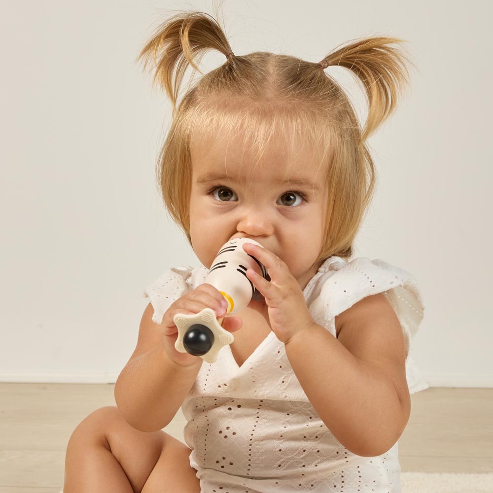 Miniland - Zebra rattle – bambina che porta alla bocca l'area dentizione
